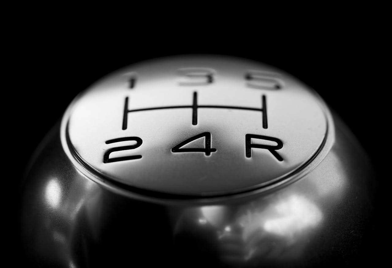 Home Detailed close-up of a stainless steel gear shift knob against a black background.